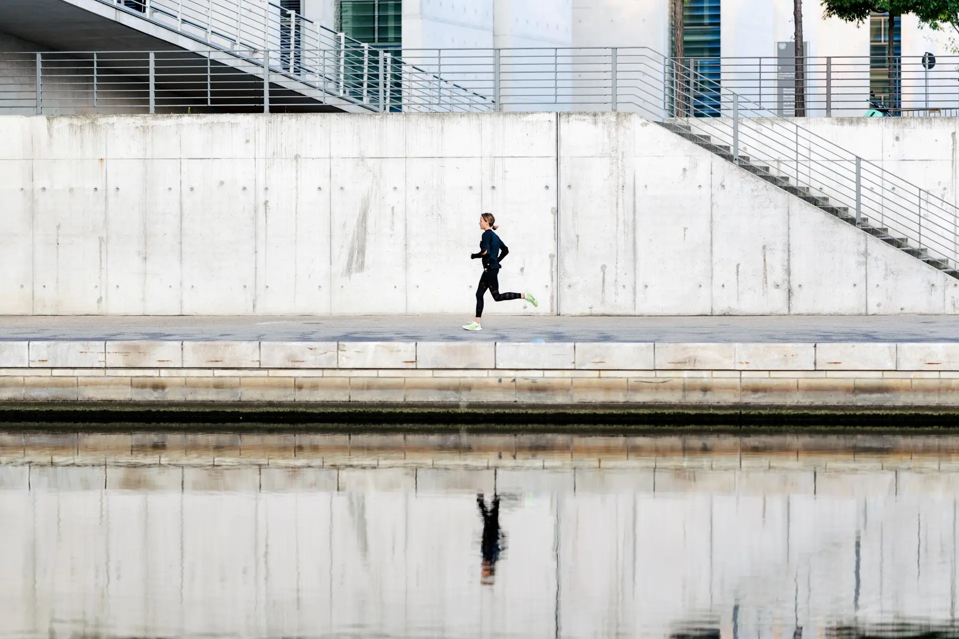 Nike Road to Berlin: Läuferin an der Spree mit Spiegelung