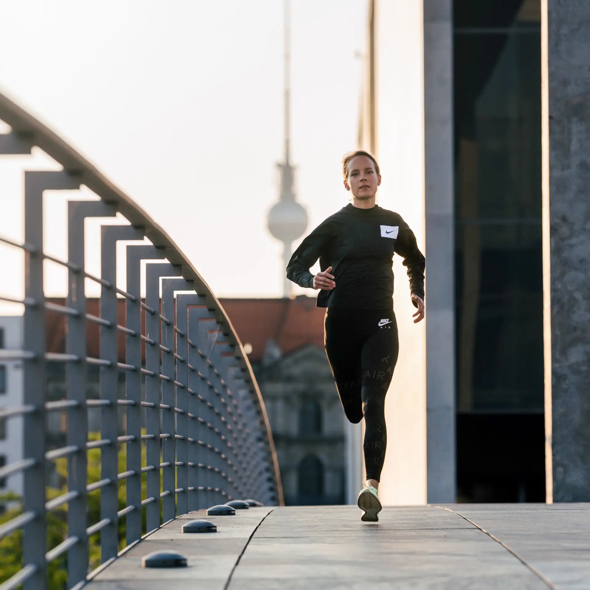 Nike Road to Berlin: Läuferin auf der Brücke vor dem Berliner Fernsehturm